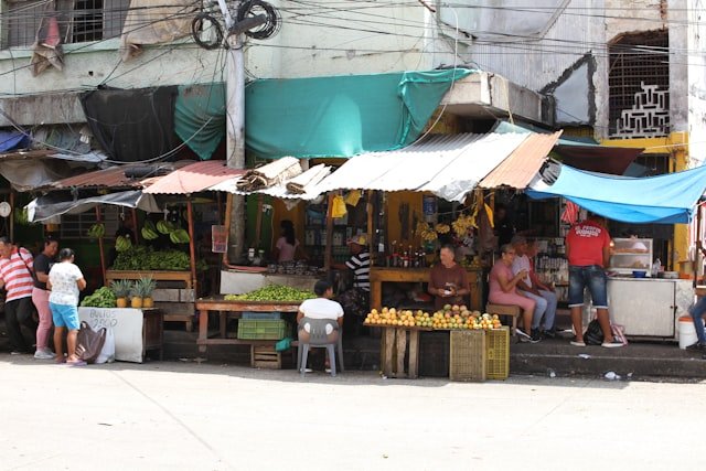 A group of people standing around a market